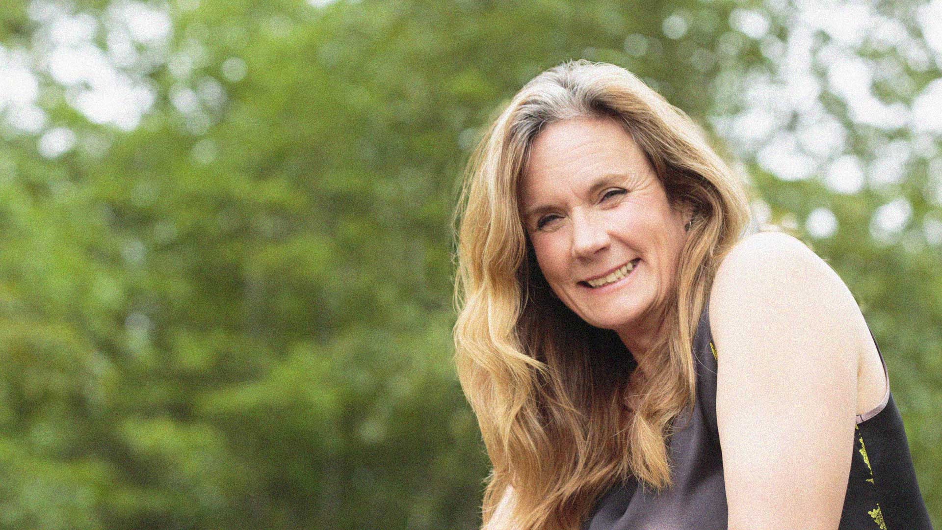 Portrait of woman outdoors with greenery in the background