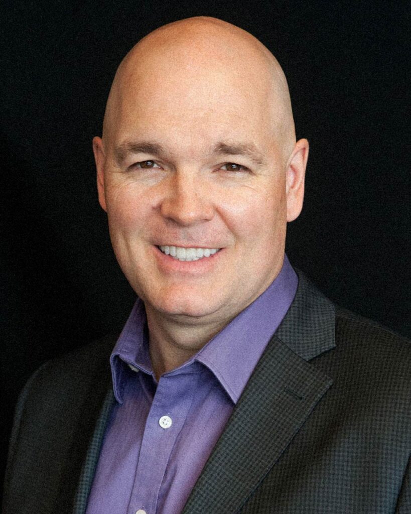 Headshot of Dean Desrosiers on black background