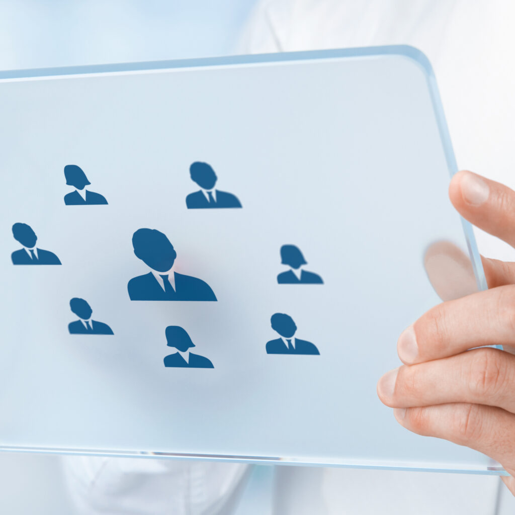 Human resources, personal audit, CRM, and assessment center concept - recruiter select employee (or team leader) represented by icon on futuristic tablet. Wide composition, office in background.